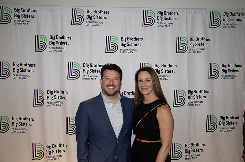 a young professional male and female smiling for a photo together