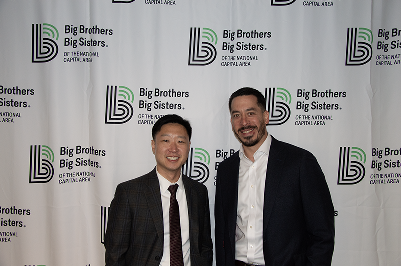 two young male professionals smiling for a photo together