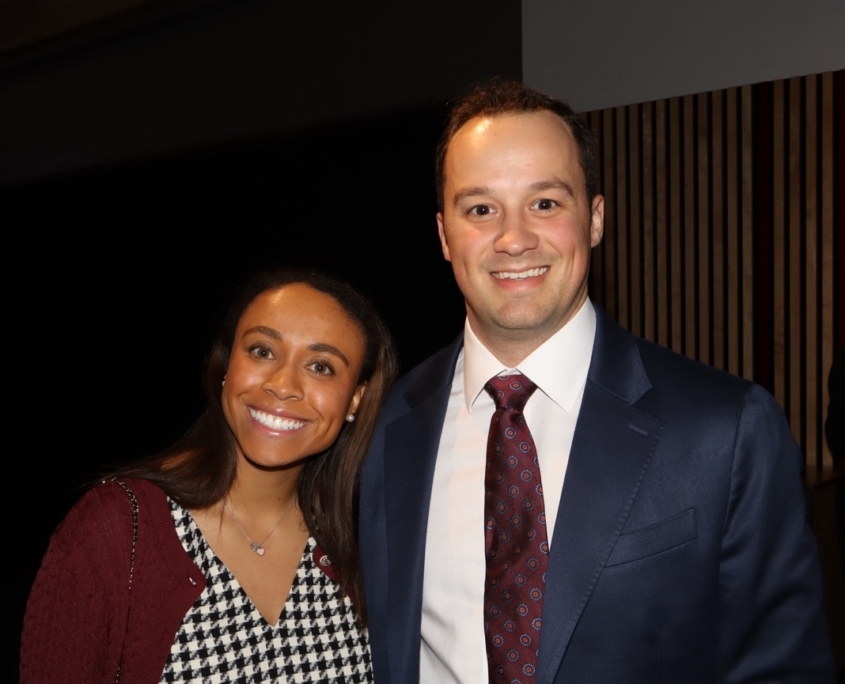 a professional female and professional male smiling for a photo together
