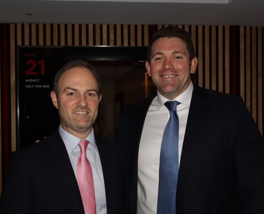 two male professionals smiling for a photo together