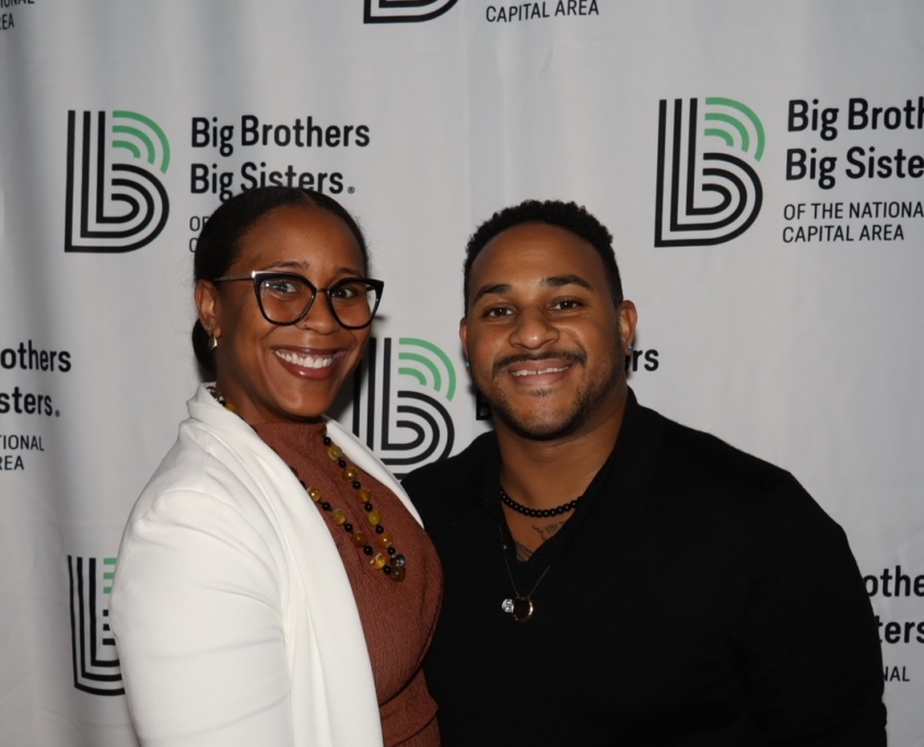 a professional female and male smiling for a photo together