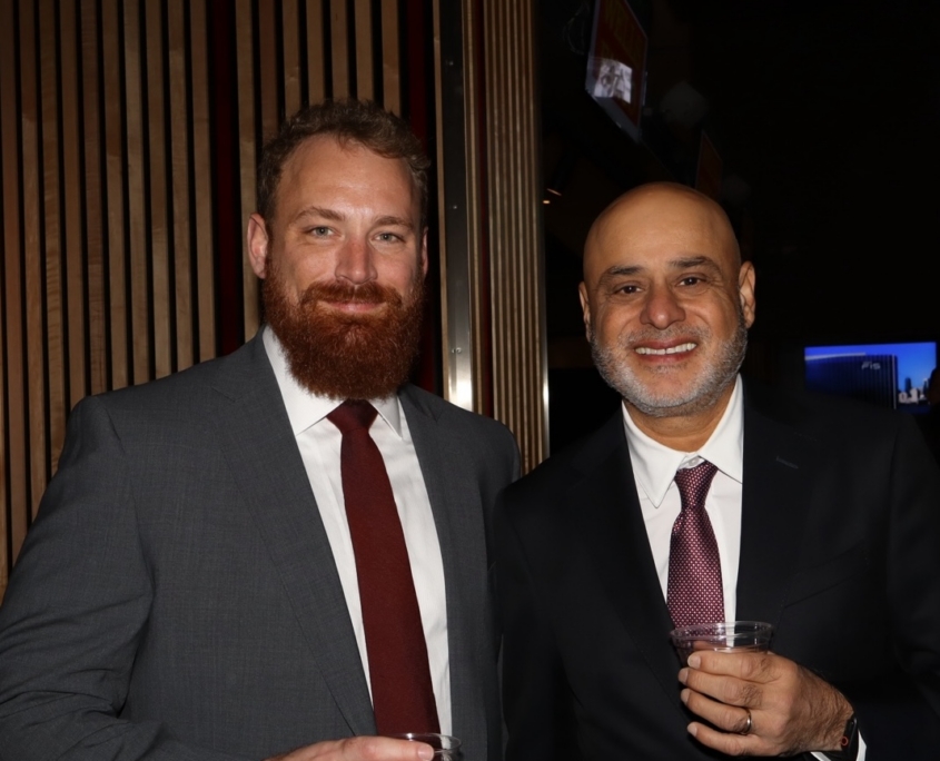 two male professionals smiling for a photo together