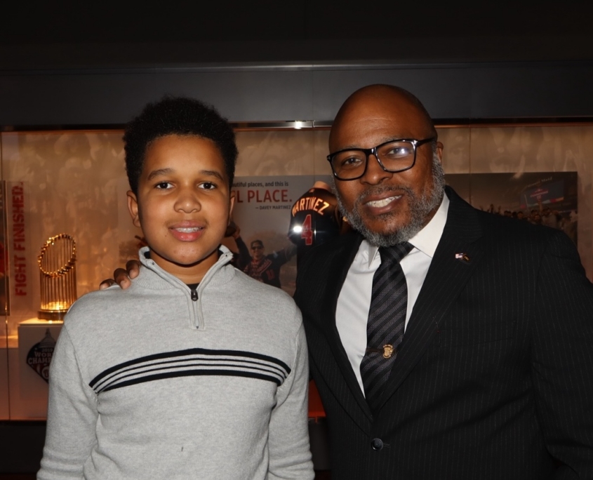 a young teenager and an adult male smiling for a photo together