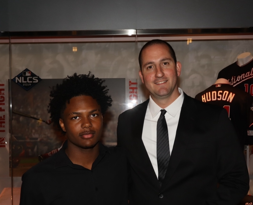 a young teenager and an adult male smiling for a photo together