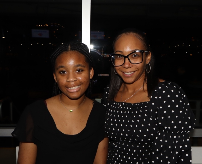 a young teenager and an adult female smiling for a photo together