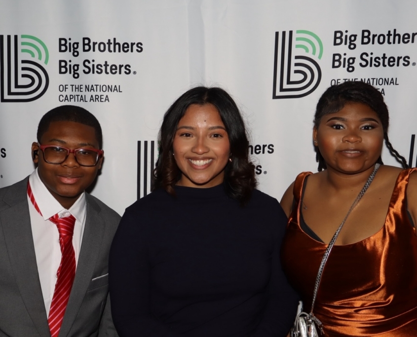 an adult female smiling next to to young teenagers