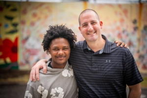 photo of an adult male with his arm around a young male